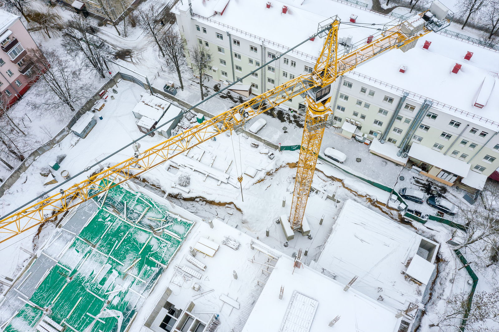 Aerial Top View Of Tall Tower Crane Working At Construction Site